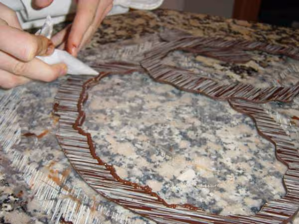 A l aide d un cornet deposser du chocolat aux endroit ou les anneaux vont se supperposser
