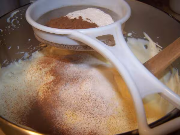 Tamiser cacao et farine sur melange blancs et jaunes