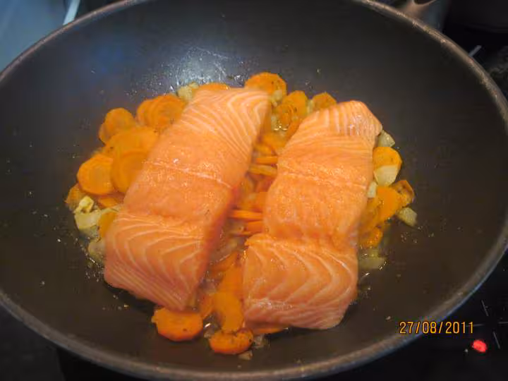 Paves de saumon rose sur un lit de carottes