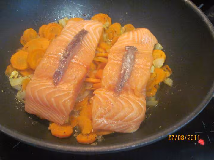 Paves de saumon rose sur un lit de carottes