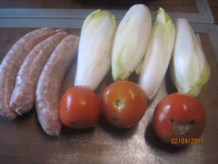 Saucisses de toulouse sur 1 lit d endives a la sauce tomates
