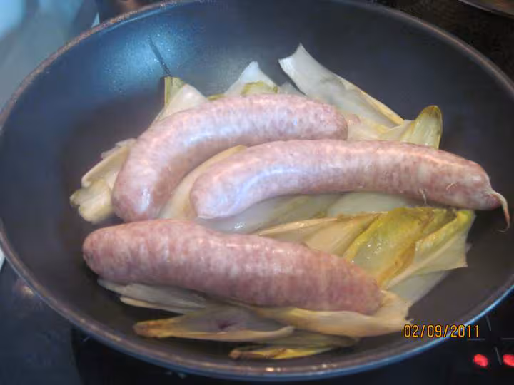 Saucisses de toulouse sur 1 lit d endives a la sauce tomates
