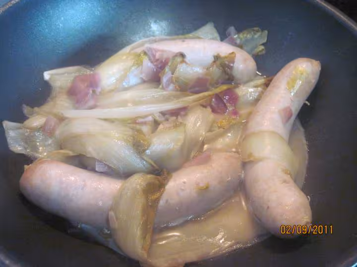 Saucisses de toulouse sur 1 lit d endives a la sauce tomates