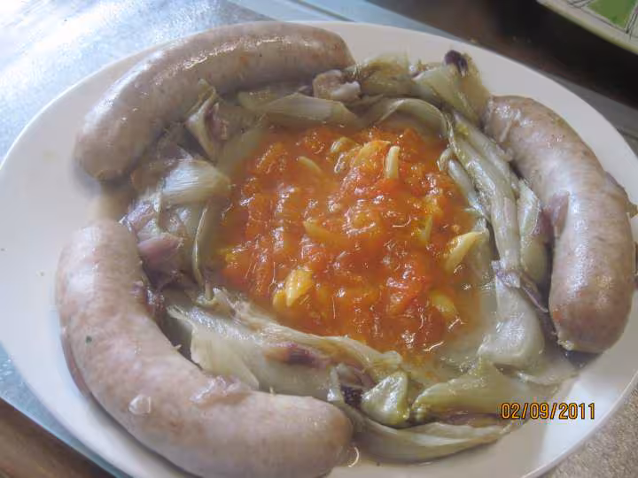 Saucisses de toulouse sur 1 lit d endives a la sauce tomates