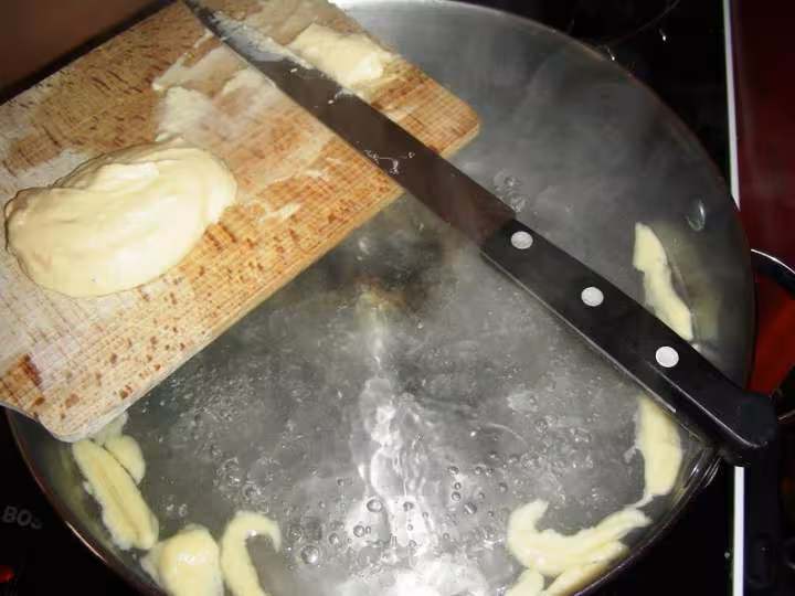 Faire glisser un morceau de pate dans l eau bouillante