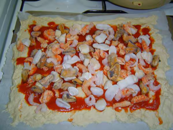 Pizza en cours de garnissage fruits de mer