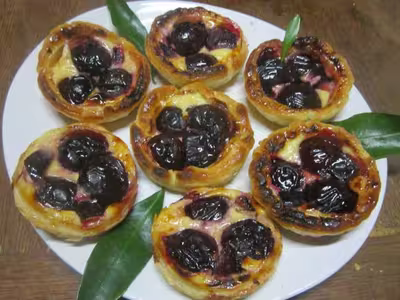 Tartelettes aux prunes rouges sur une crème.